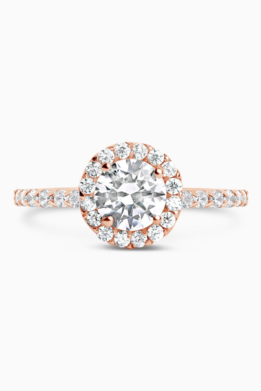 Rose Gold Round Cut Stone set on a Low Profile Setting with a Halo and Pavé Band