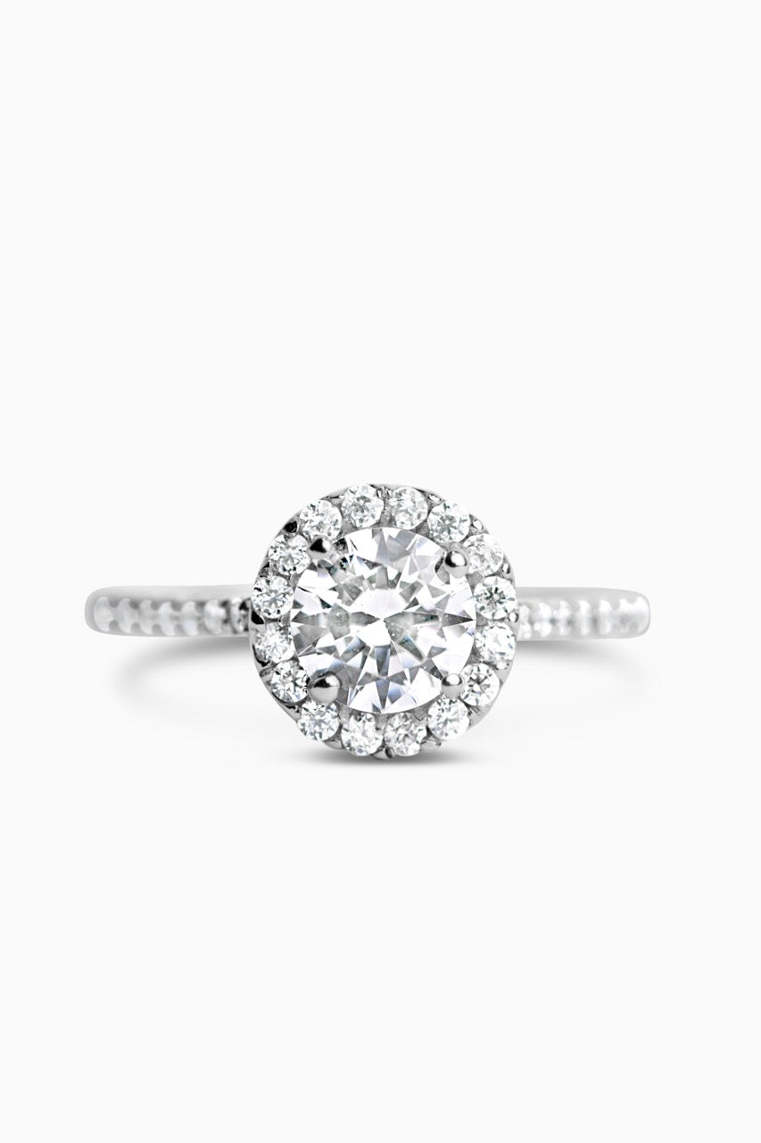 White Gold Round Cut Stone set on a Low Profile Setting with a Halo and Pavé Band